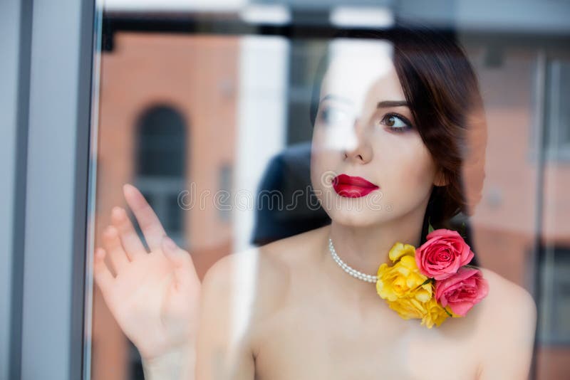 Portrait Of Beautiful Young Woman Standing Near The Window And L Stock