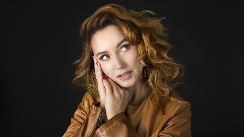 Portrait of a beautiful young woman thinking, on dark background royalty free stock photo Portrait of a beautiful young woman thinking, on dark background royalty free stock photo