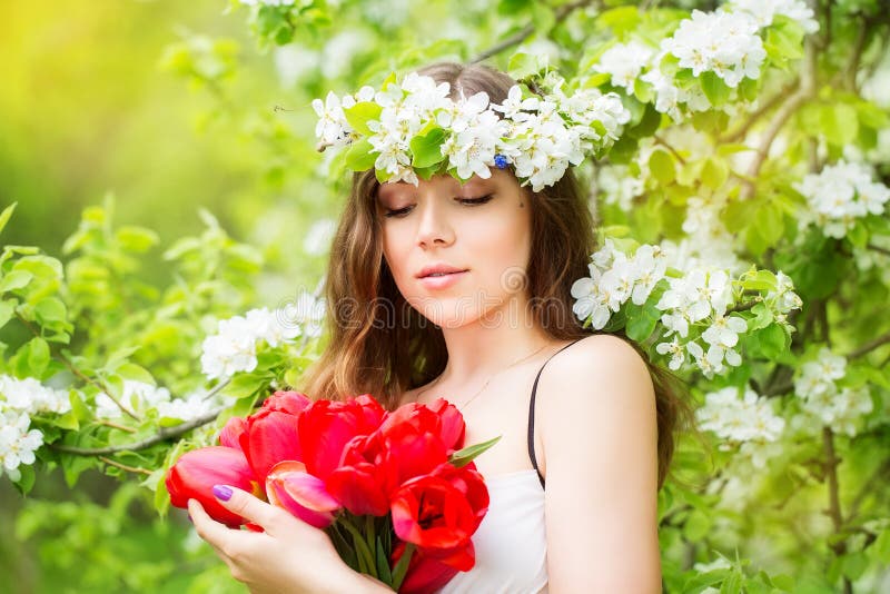 Portrait of a beautiful young woman in a wreath of spring flower