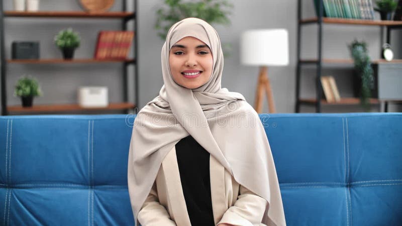 Portrait beauté mixte race turque jeune femme dans foulard sourire canapé relaxant à la maison intérieur banque de vidéos