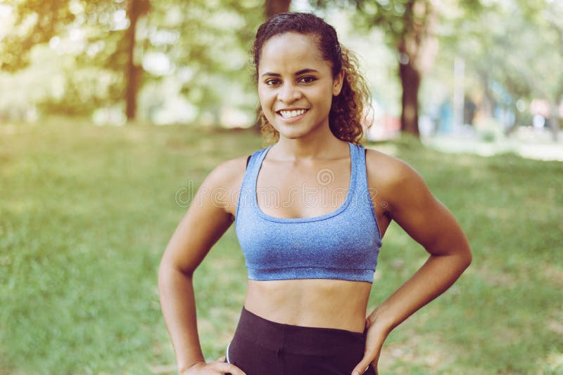 Portrait of black curly hair woman standing and resting after break workout at park,Happy and smiling,Relaxing time royalty free stock photo Portrait of black curly hair woman standing and resting after break workout at park,Happy and smiling,Relaxing time royalty free stock photo
