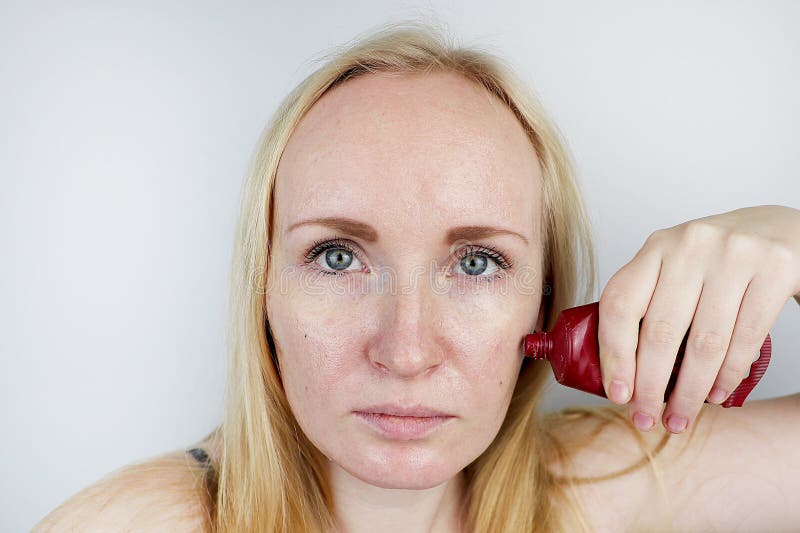 A young woman puts a gel mask on her face. Care for oily, problem skin stock photography A young woman puts a gel mask on her face. Care for oily, problem skin stock photography