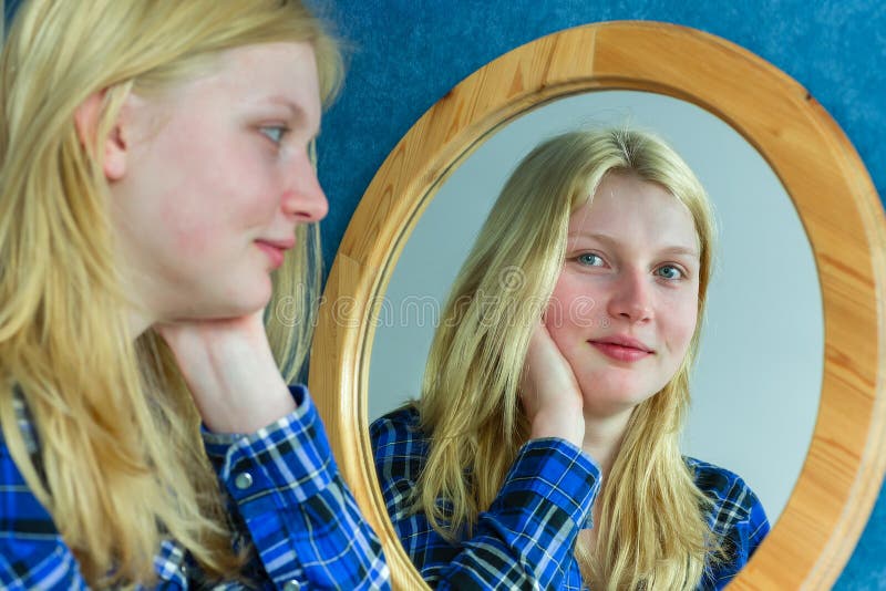 Portrait of blonde girl looking in mirror