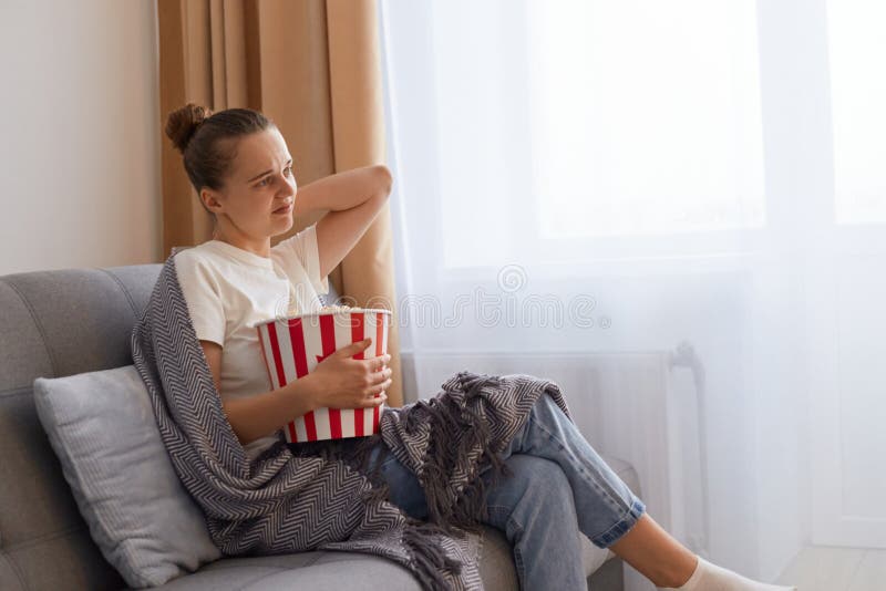 Portrait Of Bored Woman Spending Her Weekend Alone Sitting On Sofa