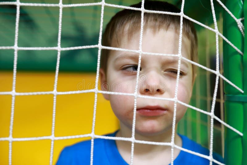 Portrait of boy behind net at playground