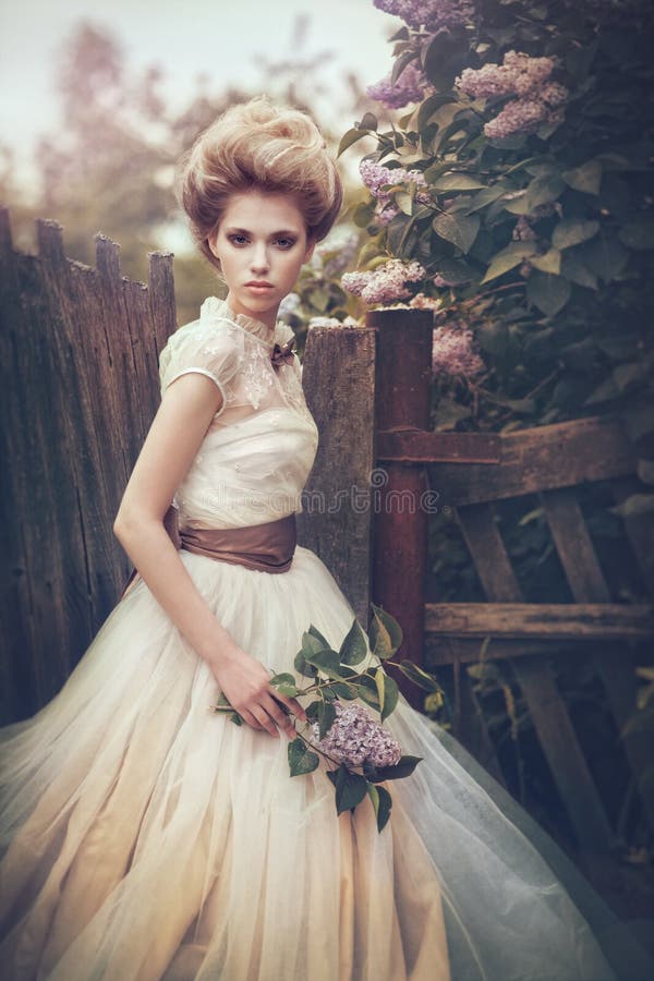 Portrait of a bride in a white dress with flowers in retro style.