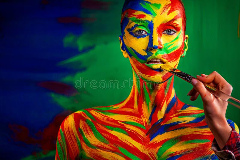 Color art face and body painting on woman for inspiration. Abstract portrait of the bright beautiful girl with colorful