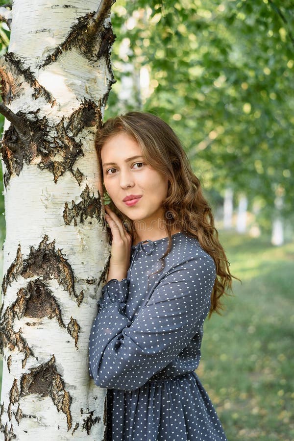 Portrait of Brunette Girl Behind the Birch Tree. Girl in Blue Dress ...