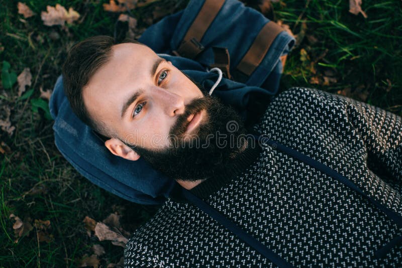 Portrait brutal bearded hipster dreamer man in the forest royalty free stock images