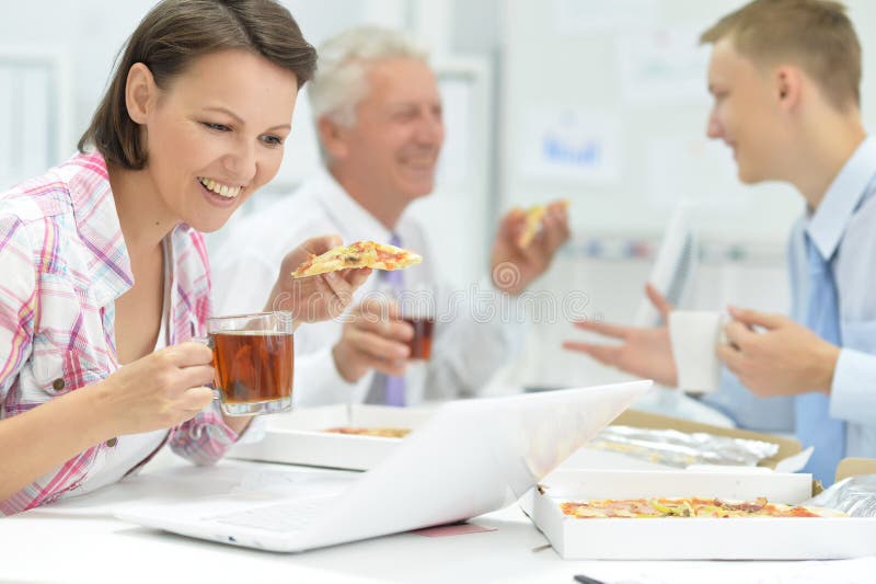 Portrait of business people having lunch together. Business people having lunch together in modern office stock images Portrait of business people having lunch together. Business people having lunch together in modern office stock images