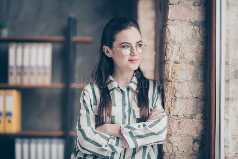 Portrait of calm peaceful minded company owner chief girl cross hands stand near window look imagine her start up