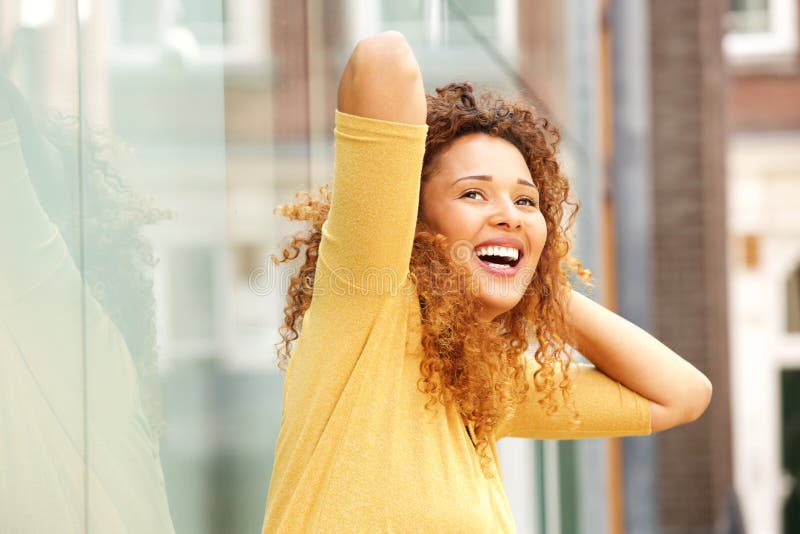 Carefree young woman laughing with hands behind head outside stock images Carefree young woman laughing with hands behind head outside stock images