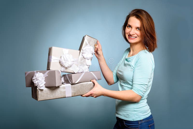 Smiling woman hold gray gift box on blue background