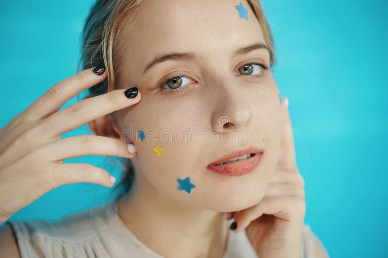 Portrait of Woman With Star Stickers on Face Looking Playful stock images