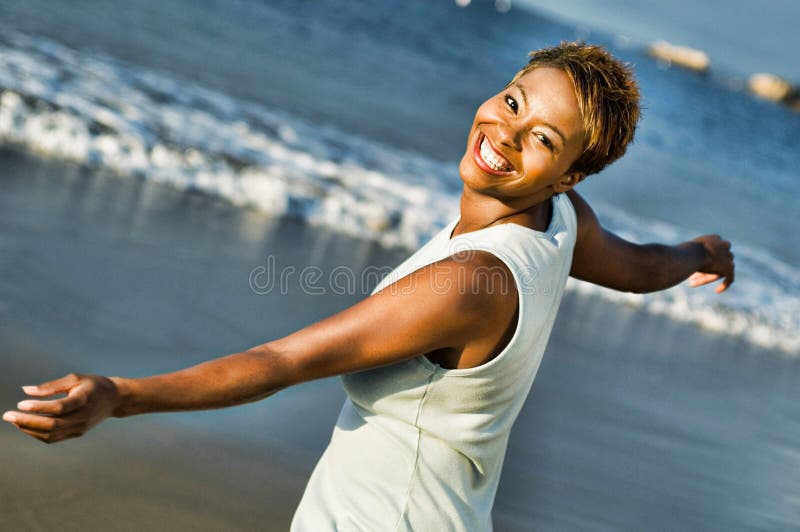 Portrait of cheerful African American woman enjoying vacation on beach. Photo of cheerful African American woman enjoying vacation on beach