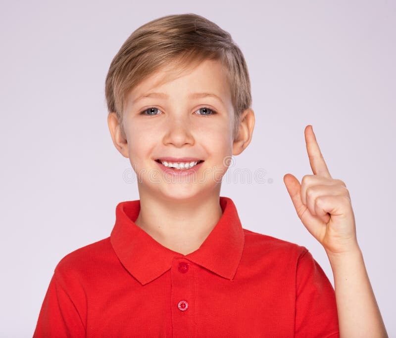 Portrait of cheerful boy with good idea -  isolated over white background. 8 year old kid pointing finger up. Child points by