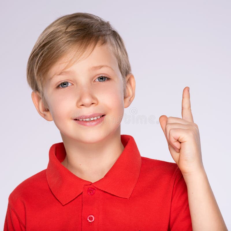 Portrait of cheerful boy with good idea -  isolated over white background. 8 year old kid pointing finger up. Child points by