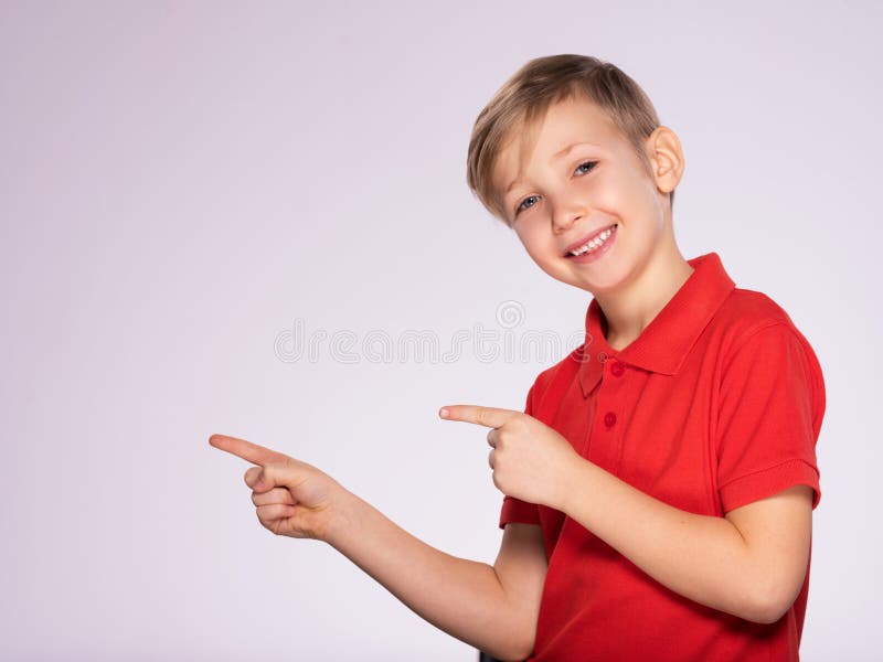 Portrait of cheerful boy pointing to the right -  isolated over white background. 8 year old kid pointing something. Child points