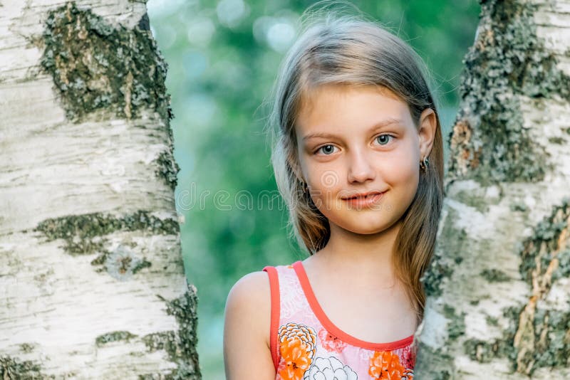 Portrait of cheerful cute little girl near the birch stock photo Portrait of cheerful cute little girl near the birch stock photo