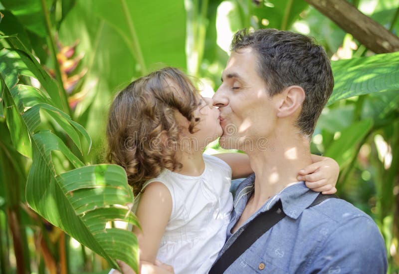 Portrait of a cheerful daughter kissing her father royalty free stock image.