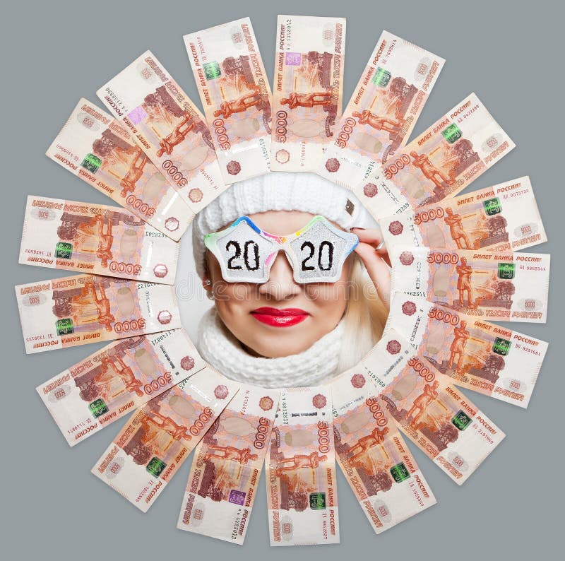Portrait of a cheerful girl in glasses with the inscription 2020 in the center of the circle of five thousand bills. royalty free stock photo Portrait of a cheerful girl in glasses with the inscription 2020 in the center of the circle of five thousand bills. royalty free stock photo