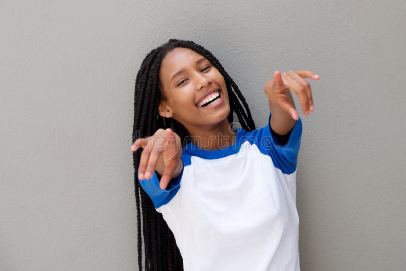 Cheerful young black woman pointing fingers against gray background stock photos Cheerful young black woman pointing fingers against gray background stock photos