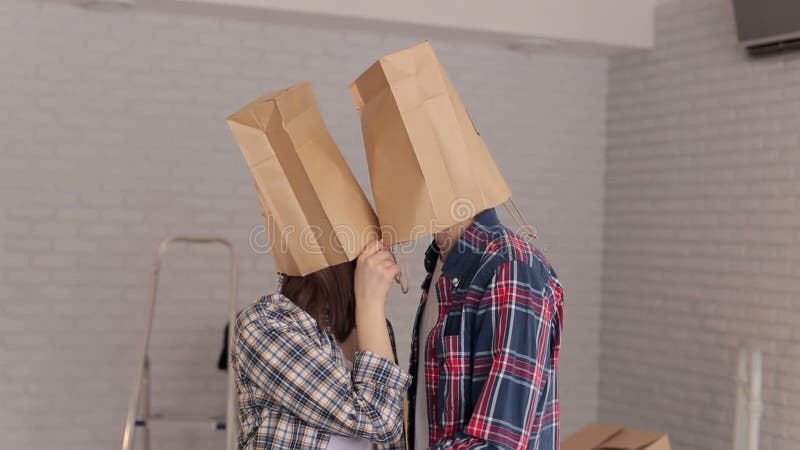 Portrait of happy young people who put on their heads paper bags, housewarming.