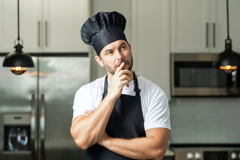 Portrait Of Chef Man In A Chef Cap In The Kitchen Man Wearing Apron portrait-of-chef-man-in-a-chef-cap-in-the-kitchen-man-wearing-apron