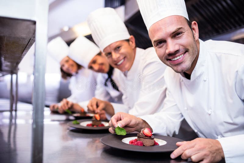 Portrait of chefs team finishing dessert plates royalty free stock photo Portrait of chefs team finishing dessert plates royalty free stock photo