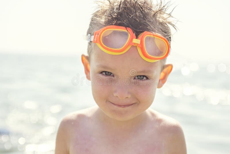 Portrait of a child in glasses for swimming against the sea. Kid in spectacles for swimming at the sea. Portrait of playful boy in stock image Portrait of a child in glasses for swimming against the sea. Kid in spectacles for swimming at the sea. Portrait of playful boy in stock image