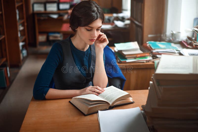 Portrait of clever student in university library.