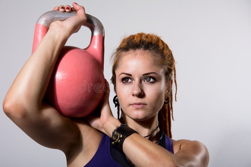 Portrait close up of young attractive female doing kettle bell e