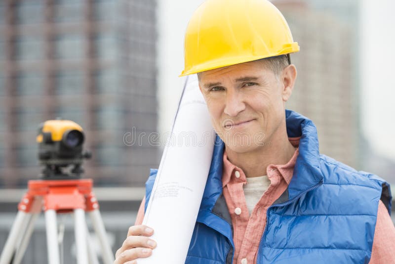 Portrait Of Confident Architect Holding Rolled Up Blueprint stock photos Portrait Of Confident Architect Holding Rolled Up Blueprint stock photos
