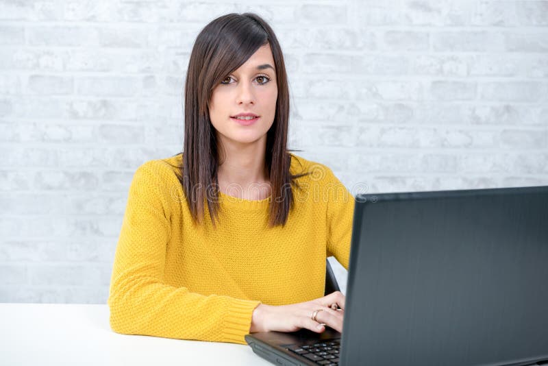 Confident young beautiful businesswoman with laptop at office