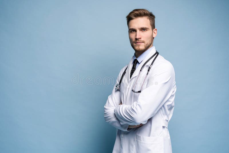 Portrait of confident young medical doctor on blue background.