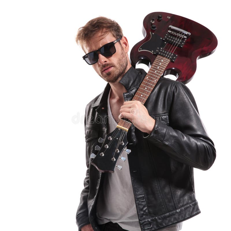 Portrait of cool rock star holding his guitar on shoulder