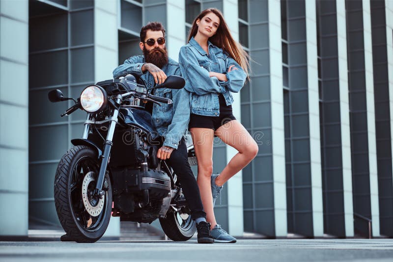 happy young couple of bikers sitting on black motorcycle on road near green  forest Stock Photo - Alamy