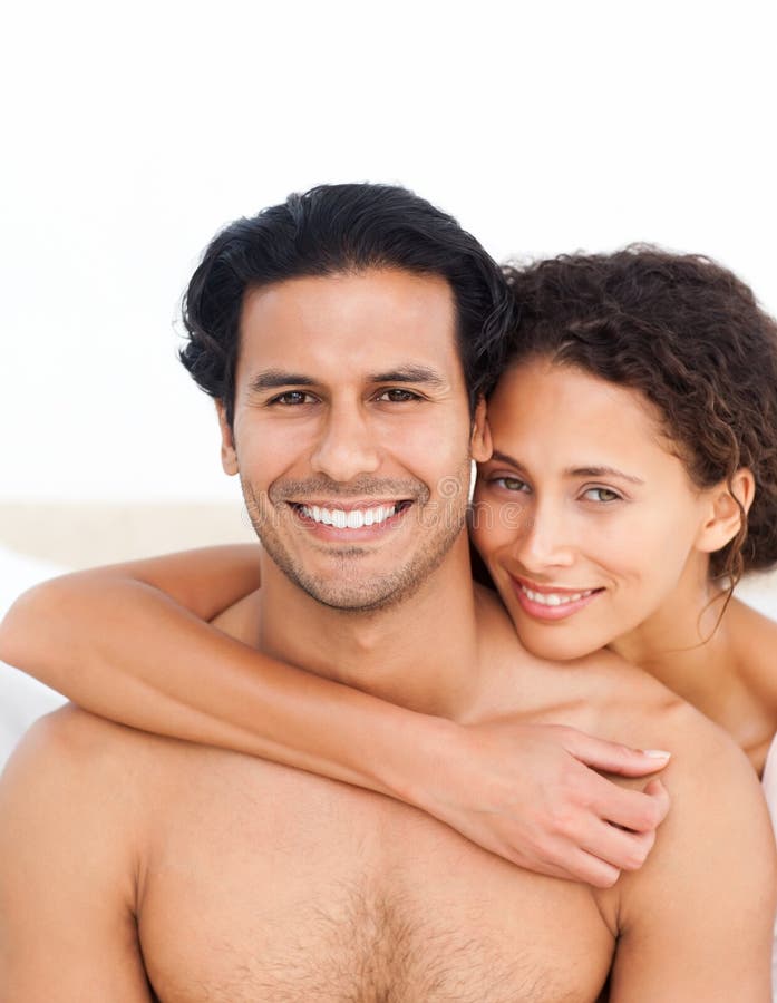 Portrait of a couple sitting on their bed relaxing at home