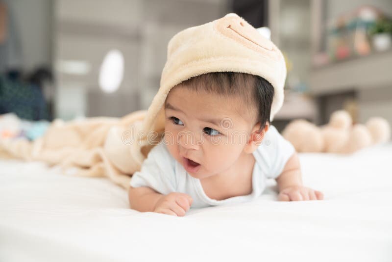 Portrait of a crawling baby on the bed in her room, Adorable baby boy in white sunny bedroom, Newborn child relaxing in bed