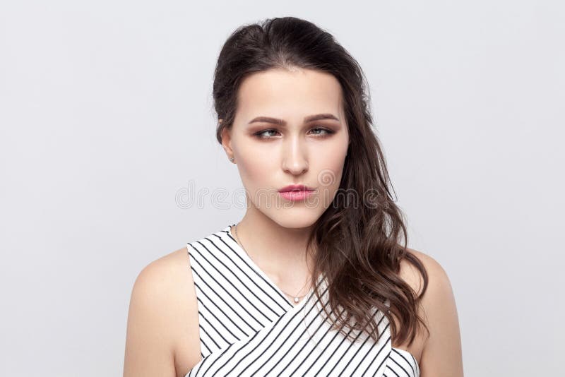 Portrait of crazy funny beautiful young brunette woman with makeup and striped dress standing and looking at camera with crossed royalty free stock image Portrait of crazy funny beautiful young brunette woman with makeup and striped dress standing and looking at camera with crossed royalty free stock image