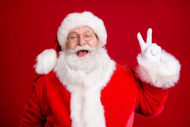 Portrait of crazy stylish santa claus enjoy x-mas christmas make v-sign wear red costume cap white gloves isolated over stock image