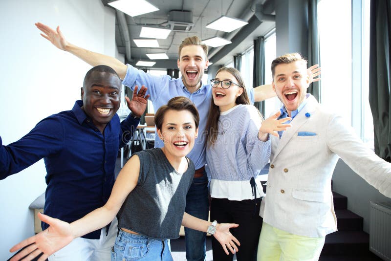 Portrait of creative business team standing together and laughing. Multiracial business people together at startup. royalty free stock images Portrait of creative business team standing together and laughing. Multiracial business people together at startup. royalty free stock images