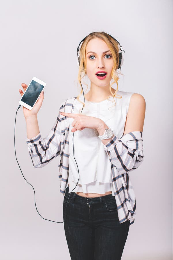 Portrait of cute beautiful blonde girl with surprised face posing on grey background, looking at camera. Happy pleased royalty free stock photo Portrait of cute beautiful blonde girl with surprised face posing on grey background, looking at camera. Happy pleased royalty free stock photo