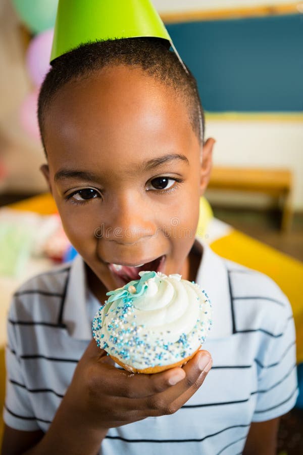 Portrait Of Cute Boy Having Cupcake During Birthday Party Stock Image