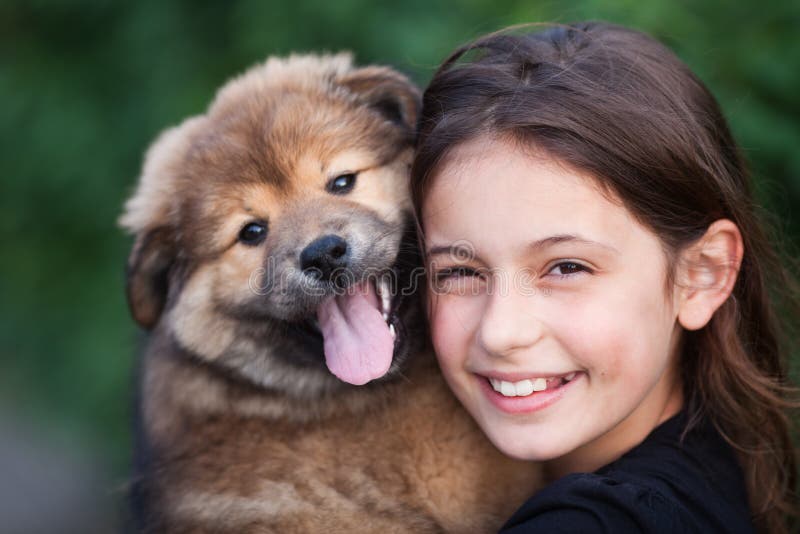 Portrait of a cute girl with her puppy