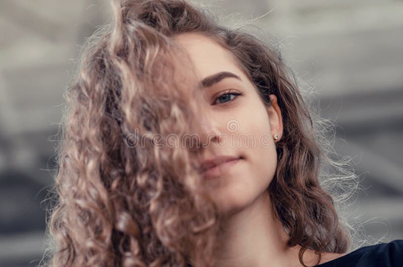 Portrait of a Cute Girl with Long Curly Hair Looking Down at Camera, Nice  Smile Stock Image - Image of camera, face: 165567659