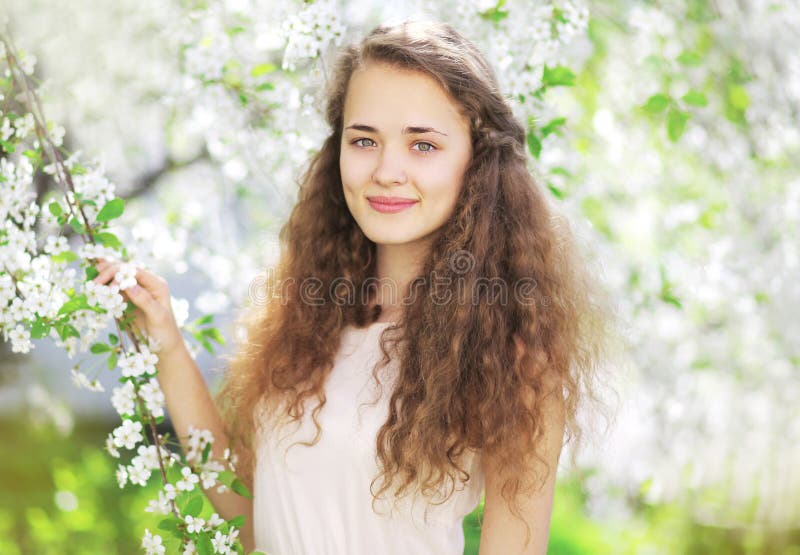 Portrait of cute girl in the spring flowering garden