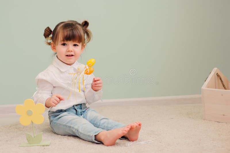 Portrait of cute happy baby girl playing with easter decorations