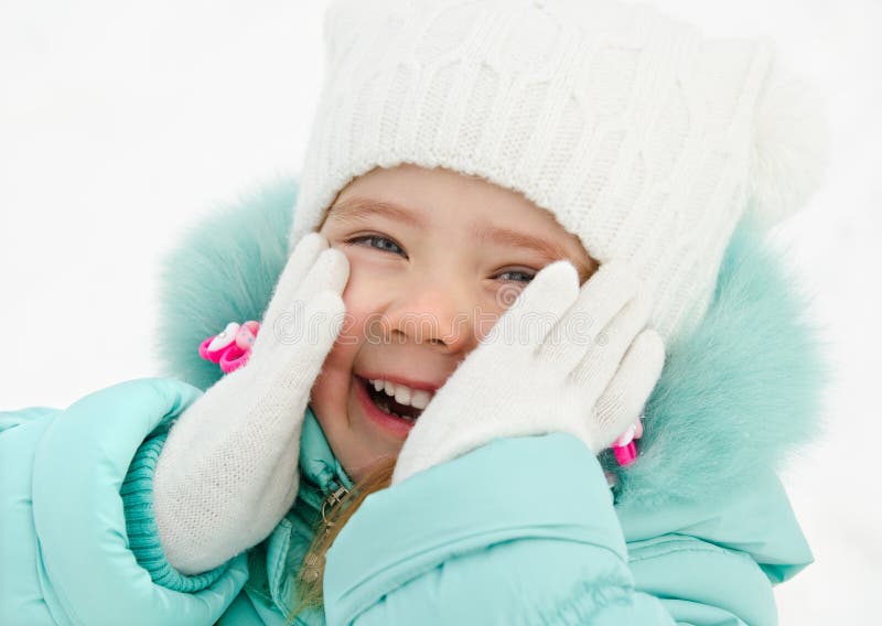 Portrait of cute laughing little girl in winter day