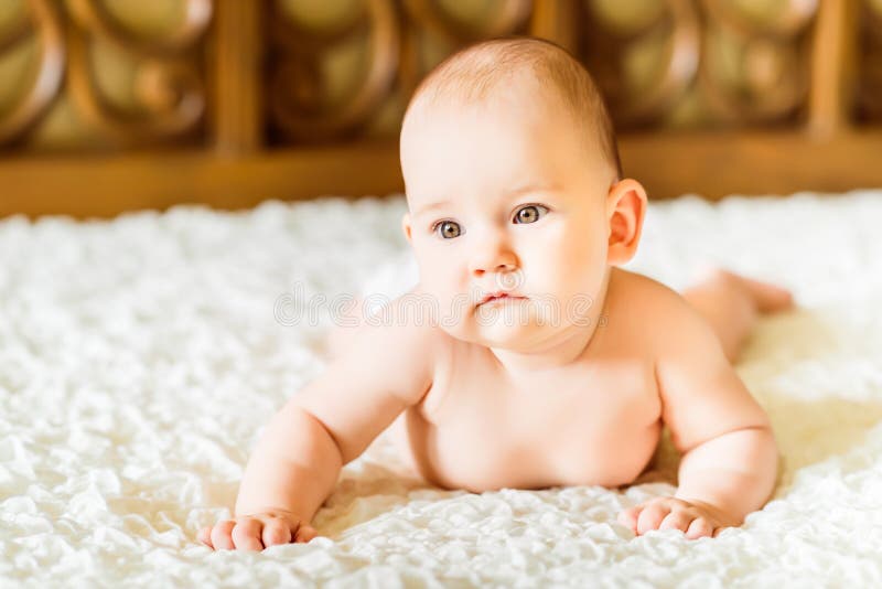 Closeup Portrait Of A Beautiful Little Baby Lying On Bed Stock Photo